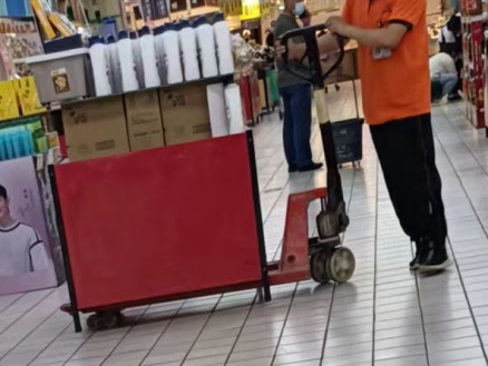 北國超市華夏店員工利用手動液壓搬運車搬運貨架